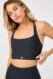 טופ מבד 4 כיוונים בגוון שחור, גזרה יותר מכסה וארוכה, הטופ ללא ריפוד נשלף וגם ללא פתח להכנסת ריפוד.