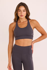 טופ ספורט בשילוב ריפוד נשלף, גומי עבה, מפתח עמוק, וחוטים בגב הטופ בגוון אפור.