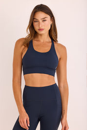 טופ ספורט בשילוב ריפוד נשלף, גומי עבה, מפתח עמוק, וחוטים בגב הטופ בגוון כחול נייבי.