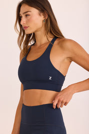 טופ ספורט בשילוב ריפוד נשלף, גומי עבה, מפתח עמוק, וחוטים בגב הטופ בגוון כחול נייבי.