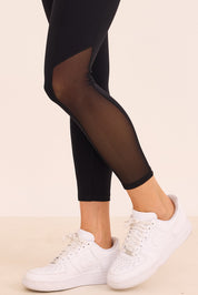 טייץ ארוך - לא מגיע עד סיומת הרגל (עד הקרסול) בגוון שחור בשילוב פסי רשת בצד.