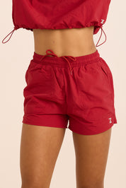 שורט מבד ניילון בשילוב טייץ פנימי קצר, שרוכי קשירה וכיסים צדדים בגוון דובדבן