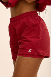 שורט מבד ניילון בשילוב טייץ פנימי קצר, שרוכי קשירה וכיסים צדדים בגוון דובדבן