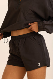 שורט מבד ניילון בשילוב טייץ פנימי קצר, שרוכי קשירה וכיסים צדדים בגוון שחור
