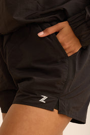 שורט מבד ניילון בשילוב טייץ פנימי קצר, שרוכי קשירה וכיסים צדדים בגוון שחור