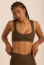 טופ מבד 4 כיוונים, עם כיווצים, מחשוף יותר פתוח בגוון חום, הטופ ללא פתח להכנסת ריפוד וגם ללא ריפוד נשלף