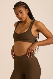 טופ מבד 4 כיוונים, עם כיווצים, מחשוף יותר פתוח בגוון חום, הטופ ללא פתח להכנסת ריפוד וגם ללא ריפוד נשלף