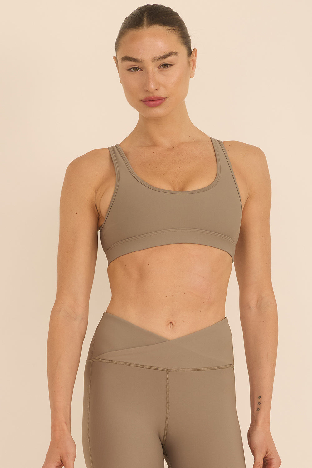 טופ בגזרה קלאסית, מבד 4 כיוונים, לא חשוף מדי, יותר סגור בצדדים, הטופ בריפוד נשלף בגוון אבן