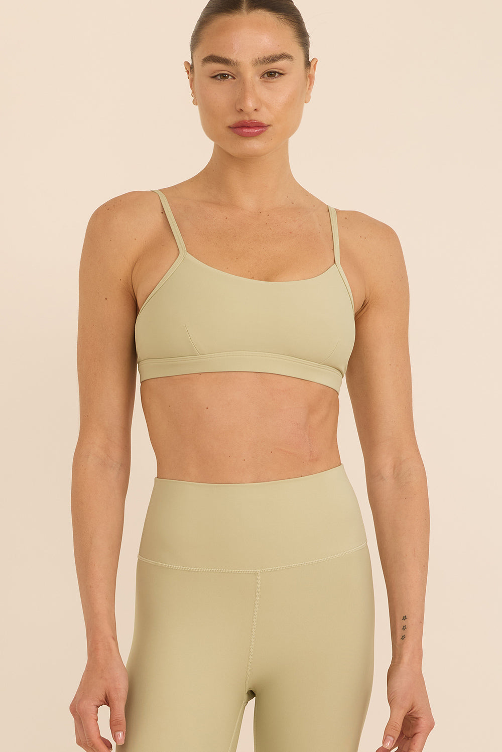 טופ מבד 4 כיוונים בשילוב רצועות מתכוונות, וריפוד נשלף בגוון שמנת- ירקרק, מהסדרה בעיצובה של עינב כהן