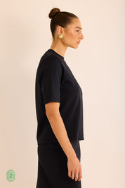 חולצה  מבד סקובה בגוון שחור,  צווארון עגול וסגור, אורך השרוול עד לתחילת המרפק- תמונה לצד