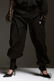 The TOUCH club.מכנס ניילון ארוך - בגוון שחור.מכנס מבד ניילון - גוון שחור. גומי במותן ושרוכים נשלפים, לוגו TOUCH בטביעת אצבע עם מחזיר אור, סיומת עם כפתור וגומי להידוק הסיומת. מאפיינים:בד ניילון - קל ונעים למגע.בגוון שחור.בגלל שילוב הצבעים - יש לכבס בנפרד ובתוכנית עדינה וקצרה. לוגו TOUCH - מחזיר אור.גומי במותן עם שרוכים נשלפים להידוק.כיסים צדדים.סיומת עם כפתור וגומי פנימי להצרת סיומת המכנס.