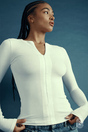 חולצת שרוול ארוך בגוון לבן, פתיחת רוכסן מקדימה (לא עד הסיומת). 