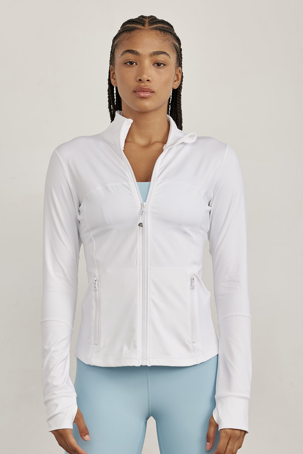 ג׳קט רוכסן מלא בגוון ללבן, בגזרה הדוקה יותר, שילוב של כיסים פרונלטיים, ומקום לאגודל.