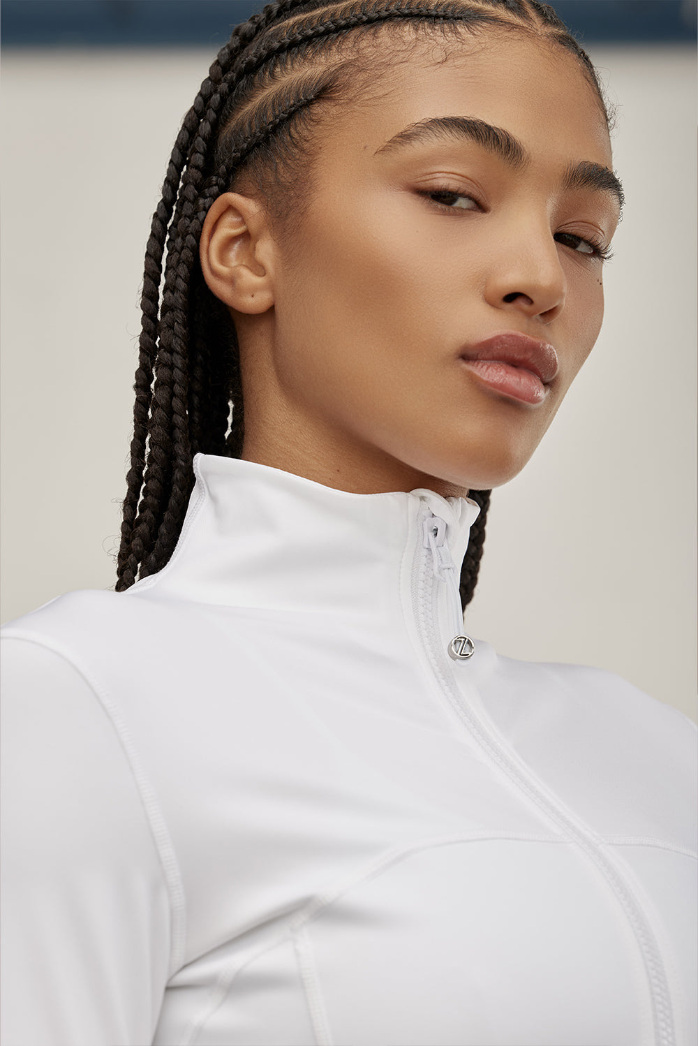 ג׳קט רוכסן מלא בגוון ללבן, בגזרה הדוקה יותר, שילוב של כיסים פרונלטיים, ומקום לאגודל.