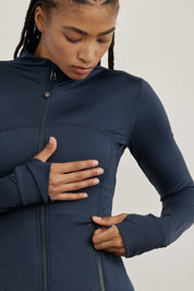 ג׳קט רוכסן מלא בגוון כחול, בגזרה הדוקה יותר, שילוב של כיסים פרונלטיים, ומקום לאגודל.