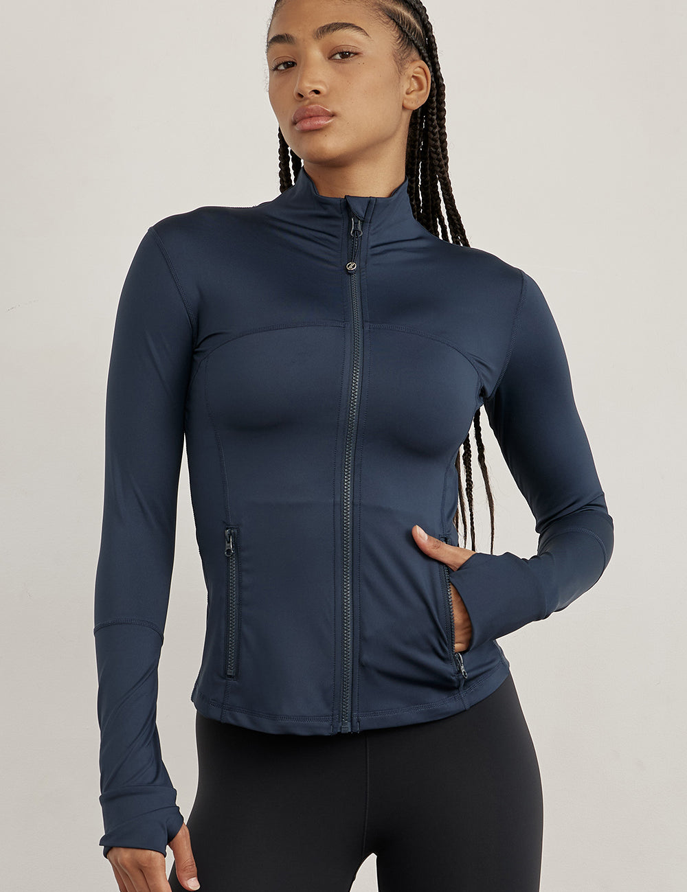 ג׳קט רוכסן מלא בגוון כחול, בגזרה הדוקה יותר, שילוב של כיסים פרונלטיים, ומקום לאגודל.