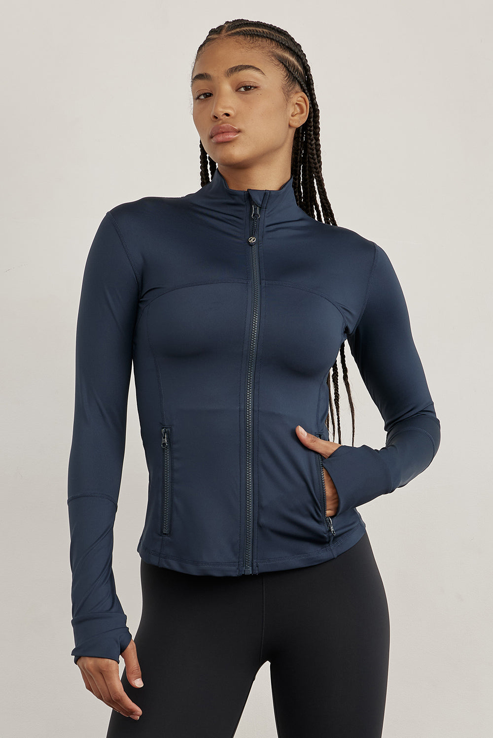 ג׳קט רוכסן מלא בגוון כחול, בגזרה הדוקה יותר, שילוב של כיסים פרונלטיים, ומקום לאגודל.