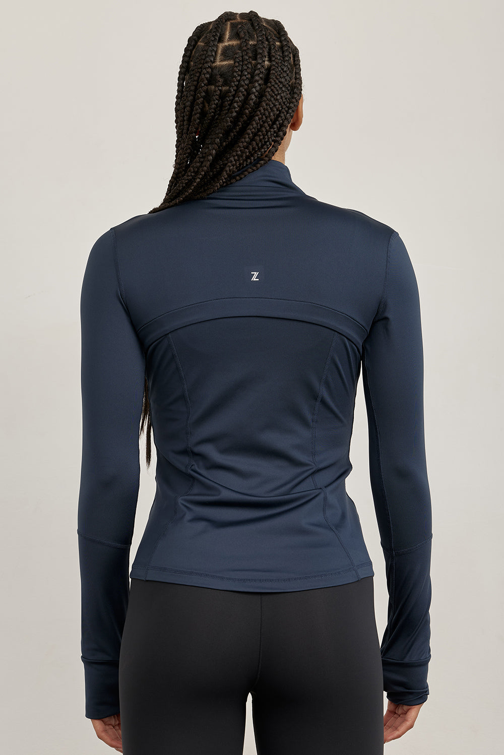 ג׳קט רוכסן מלא בגוון כחול, בגזרה הדוקה יותר, שילוב של כיסים פרונלטיים, ומקום לאגודל.