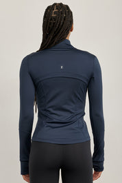 ג׳קט רוכסן מלא בגוון כחול, בגזרה הדוקה יותר, שילוב של כיסים פרונלטיים, ומקום לאגודל.