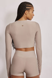 חולצת קרופ שרוול ארוך מהקולקציה בעיצובה של אדל בספלוב, בשילוב של חיתוכי לייזר, חיתוך לב בפריט ללא שכבה פנימית, מקום לאגודל, גוון אפור.