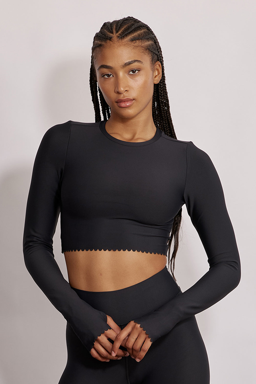 חולצת קרופ שרוול ארוך מהקולקציה בעיצובה של אדל בספלוב, בשילוב של חיתוכי לייזר, חיתוך לב בפריט ללא שכבה פנימית, מקום לאגודל, גוון שחור.