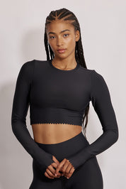 חולצת קרופ שרוול ארוך מהקולקציה בעיצובה של אדל בספלוב, בשילוב של חיתוכי לייזר, חיתוך לב בפריט ללא שכבה פנימית, מקום לאגודל, גוון שחור.