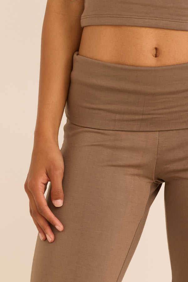 מכנס מתרחב מבד comfy+ מהסדרה של עינב כהן, חגורה גבוהה אשר ניתנת לקיפול, הדגם מיועד ליום-יום, ולא לאימונים, אינו מנדף זיעה ואינו מחטב. גוון קאמל-חום