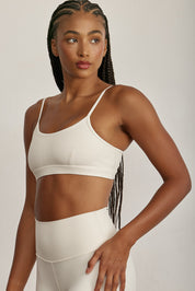 FABRIC: 4 WAY STRETCH FABRIC.טופ מבד 4 כיוונים המתקדם ביותר שלנו, אשר מאופיין באלסטיות ניכרת לאורך כל ארבעת הצירים הראשיים, הבגד עוקב בצורה מושלמת אחר תנועות הגוף ומבטיח חופש פעולה מירבי.גזרה קלאסית קצרה ומחמיאההטופ בשילוב רצועות מתכווננות בגב הטופ.הטופ בשילוב ריפוד נשלף.גוון שמנת.