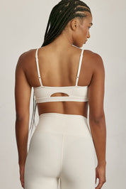 FABRIC: 4 WAY STRETCH FABRIC.טופ מבד 4 כיוונים המתקדם ביותר שלנו, אשר מאופיין באלסטיות ניכרת לאורך כל ארבעת הצירים הראשיים, הבגד עוקב בצורה מושלמת אחר תנועות הגוף ומבטיח חופש פעולה מירבי.גזרה קלאסית קצרה ומחמיאההטופ בשילוב רצועות מתכווננות בגב הטופ.הטופ בשילוב ריפוד נשלף.גוון שמנת.