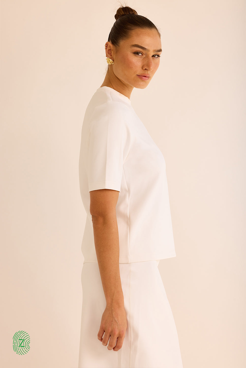 חולצה  מבד סקובה בגוון לבן,  צווארון עגול וסגור, אורך השרוול עד לתחילת המרפק- תמונה לצד 