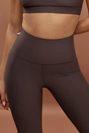 טייץ מבד 4 כיוונים, ארוך בגזרה גבוהה, בגוון ממשפחת החומים (תערובת של מספר גוונים ולא גוון ספציפי).