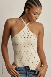 בגד גוף מבד 4 כיוונים.התחתון למטה הוא בגזרה חוטיני.הבגד גוף ללא שכבה פנימית באזור החזה.הבגד גוף ללא ריפוד נשלף וגם ללא תיקתקים.בגב הבגד גוף בהיעדר מתיחה הפתח בגב יכול להיות רופף.גוון קרם עם נקודות שחורות.