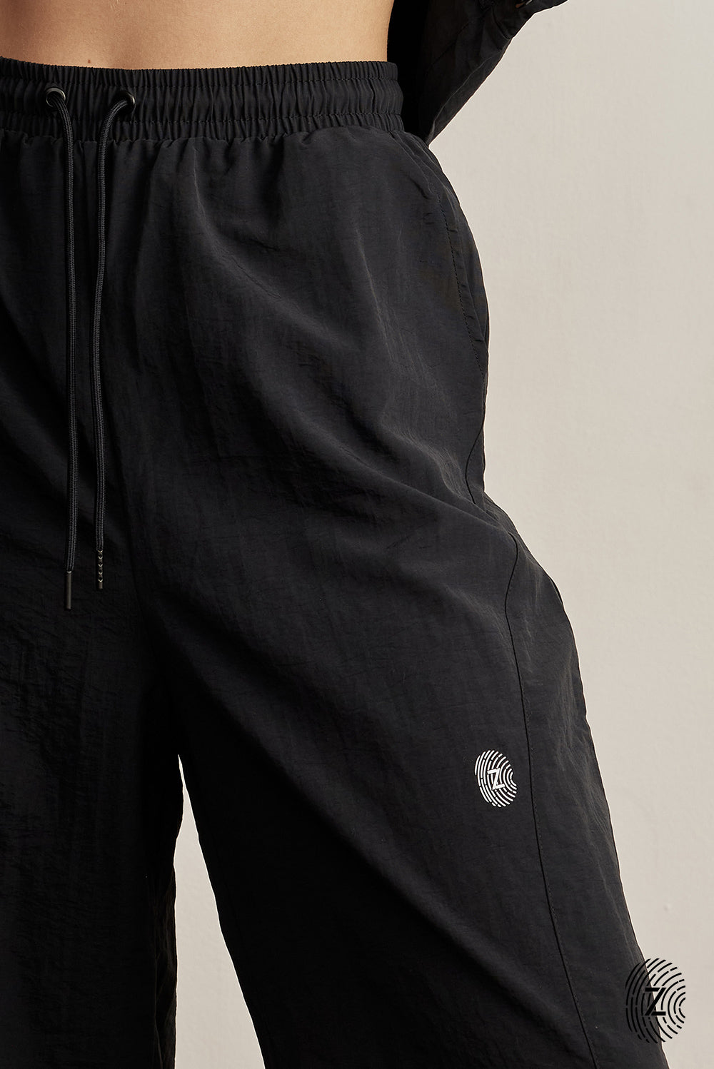 The TOUCH club.מכנס ניילון ארוך - בגוון שחור.מכנס מבד ניילון - גוון שחור. גומי במותן ושרוכים נשלפים, לוגו TOUCH בטביעת אצבע עם מחזיר אור, סיומת עם כפתור וגומי להידוק הסיומת. מאפיינים:בד ניילון - קל ונעים למגע.בגוון שחור.בגלל שילוב הצבעים - יש לכבס בנפרד ובתוכנית עדינה וקצרה. לוגו TOUCH - מחזיר אור.גומי במותן עם שרוכים נשלפים להידוק.כיסים צדדים.סיומת עם כפתור וגומי פנימי להצרת סיומת המכנס.