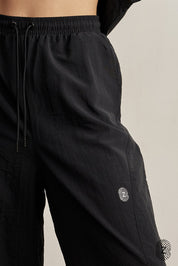 The TOUCH club.מכנס ניילון ארוך - בגוון שחור.מכנס מבד ניילון - גוון שחור. גומי במותן ושרוכים נשלפים, לוגו TOUCH בטביעת אצבע עם מחזיר אור, סיומת עם כפתור וגומי להידוק הסיומת. מאפיינים:בד ניילון - קל ונעים למגע.בגוון שחור.בגלל שילוב הצבעים - יש לכבס בנפרד ובתוכנית עדינה וקצרה. לוגו TOUCH - מחזיר אור.גומי במותן עם שרוכים נשלפים להידוק.כיסים צדדים.סיומת עם כפתור וגומי פנימי להצרת סיומת המכנס.