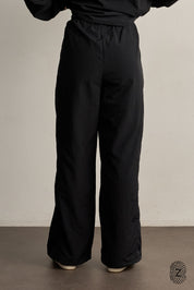 The TOUCH club.מכנס ניילון ארוך - בגוון שחור.מכנס מבד ניילון - גוון שחור. גומי במותן ושרוכים נשלפים, לוגו TOUCH בטביעת אצבע עם מחזיר אור, סיומת עם כפתור וגומי להידוק הסיומת. מאפיינים:בד ניילון - קל ונעים למגע.בגוון שחור.בגלל שילוב הצבעים - יש לכבס בנפרד ובתוכנית עדינה וקצרה. לוגו TOUCH - מחזיר אור.גומי במותן עם שרוכים נשלפים להידוק.כיסים צדדים.סיומת עם כפתור וגומי פנימי להצרת סיומת המכנס.