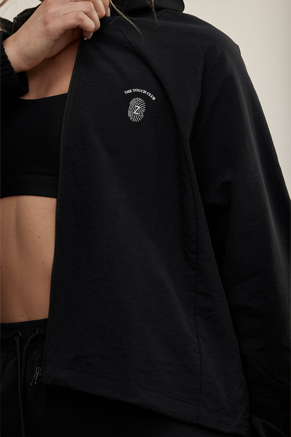 The TOUCH club.ג׳קט ניילון - רוכסן מלא, בגוון שחור.לתשומת לבך - הג׳קט אינו מסתיים בבד רשת,  בתמונה הראשית של ספיר יש שילוב נפרד של בד רשת, הג׳קט עצמו הוא כמו בשאר התמונות.סטייל ופונקציונליות במוצר אחד: ג׳קט מבד ניילון בצבע שחור. רוכסן מלא, לוגו TOUCH בטביעת אצבע עם מחזיר אור וכפתורים עם שרוך פנימי להצרת הג׳קט.מאפיינים:בד ניילון - קל ונעים למגע.בגוון שחור.בגלל שילוב הצבעים - יש לכבס בנפרד ובתוכנית עדינה וקצרה. רוכסן מלא.לוגו TOUCH - מחזיר אור. שילוב של כפתור פנימי עם שרוך לצורך הצרת הפריט.סיומת השרוול עם גומ