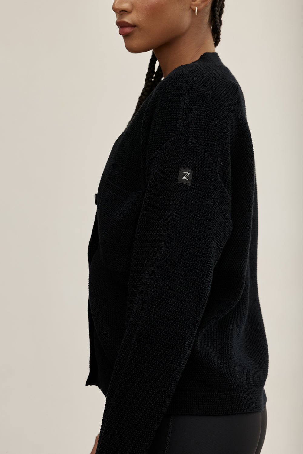 קרדיגן Zקרדיגן קלאסי, עשוי בד סרוג רך ונעים למגע. הגזרה הרפויה משתלבת בקלות עם כל לוק ומתאימה ליום ולערב. סגירת כפתורים קדמית, מפתח V וכיס קדמי. לוגו Z בגוון אפור על שרוול הקרדיגן. -בד סרוג רך ונושם.--סגירת כפתורים קדמית.-מפתח V מחמיא.-כיס קדמי.-צבע: שחור.