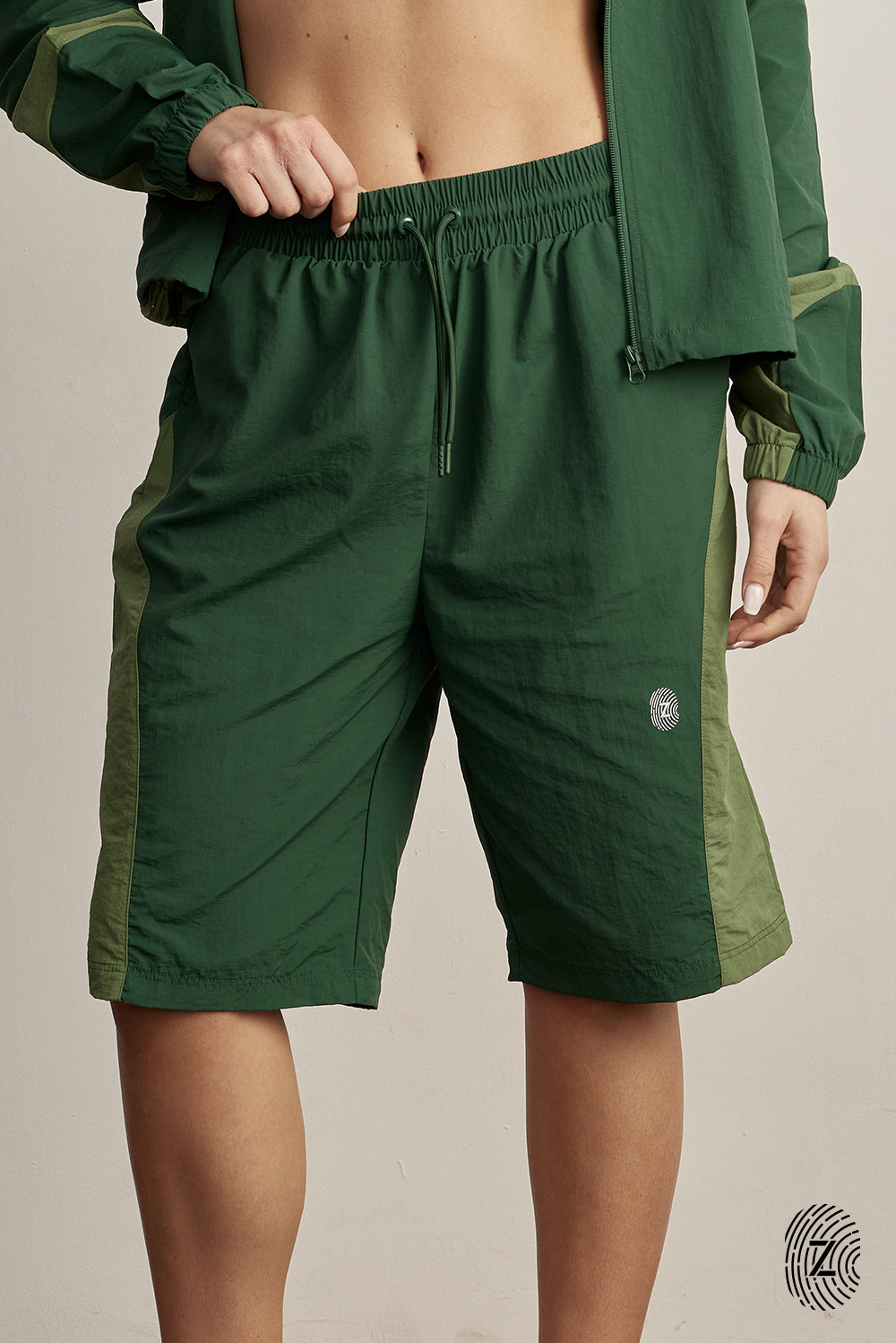 The TOUCH club.ברמודת ניילון - בשילוב של 2 גוונים - ירוק בקבוק וירוק בהיר.ברמודת מבד ניילון - גוון עיקרי ירוק בקבוק ושילוב של גוון ירוק בהיר. גומי במותן ושרוכים נשלפים, לוגו TOUCH בטביעת אצבע עם מחזיר אור. מאפיינים:בד ניילון - קל ונעים למגע.בגוון ירוק בקבוק ושילוב ירוק בהיר.בגלל שילוב הצבעים - יש לכבס בנפרד ובתוכנית עדינה וקצרה. לוגו TOUCH - מחזיר אור.גומי במותן עם שרוכים נשלפים להידוק.