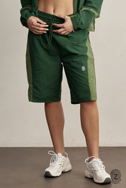 The TOUCH club.ברמודת ניילון - בשילוב של 2 גוונים - ירוק בקבוק וירוק בהיר.ברמודת מבד ניילון - גוון עיקרי ירוק בקבוק ושילוב של גוון ירוק בהיר. גומי במותן ושרוכים נשלפים, לוגו TOUCH בטביעת אצבע עם מחזיר אור. מאפיינים:בד ניילון - קל ונעים למגע.בגוון ירוק בקבוק ושילוב ירוק בהיר.בגלל שילוב הצבעים - יש לכבס בנפרד ובתוכנית עדינה וקצרה. לוגו TOUCH - מחזיר אור.גומי במותן עם שרוכים נשלפים להידוק.