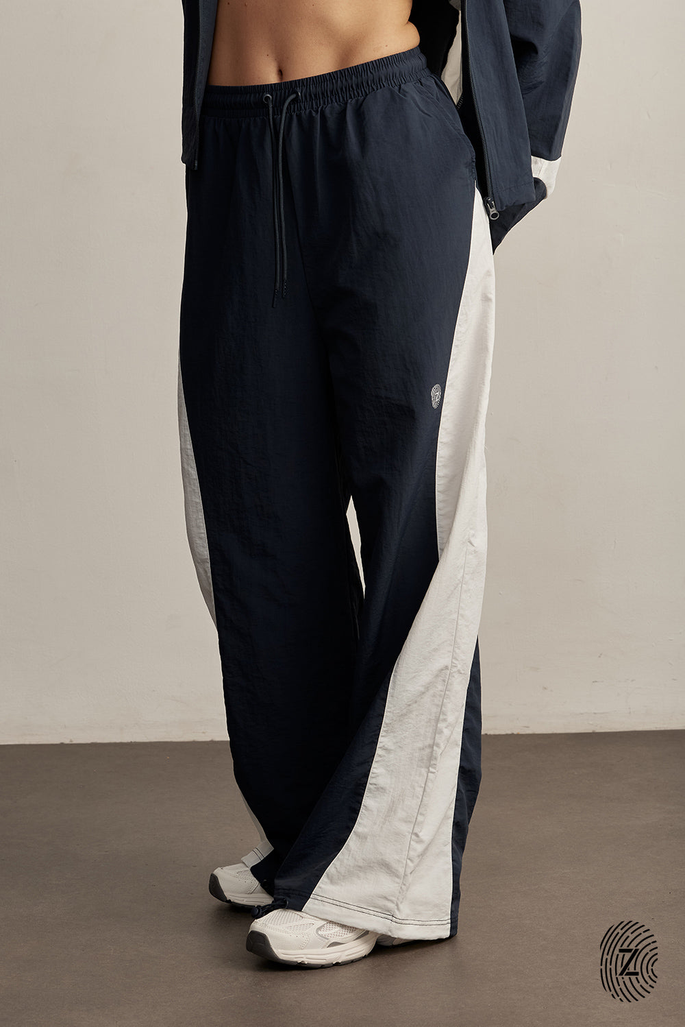 The TOUCH club.מכנס ניילון ארוך - בשילוב של 2 גוונים - כחול ולבן/קרם.מכנס מבד ניילון - גוון עיקרי כחול ושילוב של גוון לבן/קרם. גומי במותן ושרוכים נשלפים, לוגו TOUCH בטביעת אצבע עם מחזיר אור, סיומת עם כפתור וגומי להידוק הסיומת. מאפיינים:בד ניילון - קל ונעים למגע.בגוון כחול ושילוב לבן / קרם.בגלל שילוב הצבעים - יש לכבס בנפרד ובתוכנית עדינה וקצרה. לוגו TOUCH - מחזיר אור.גומי במותן עם שרוכים נשלפים להידוק.כיסים צדדים.סיומת עם כפתור וגומי פנימי להצרת סיומת המכנס.